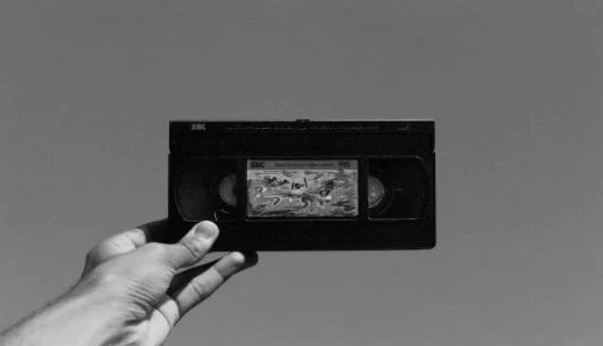 An individual holding onto a VHS tape.