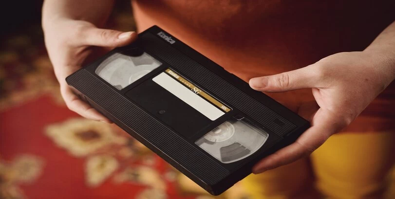 A person holding a VHS tape.