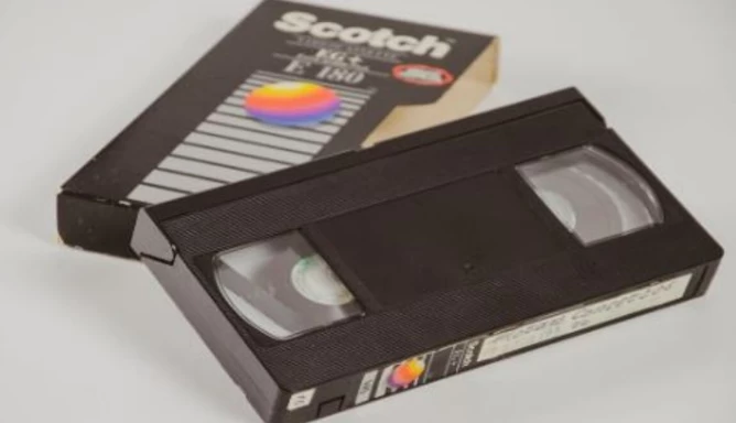 A VHS tape and the tape box cover are placed on a white background.